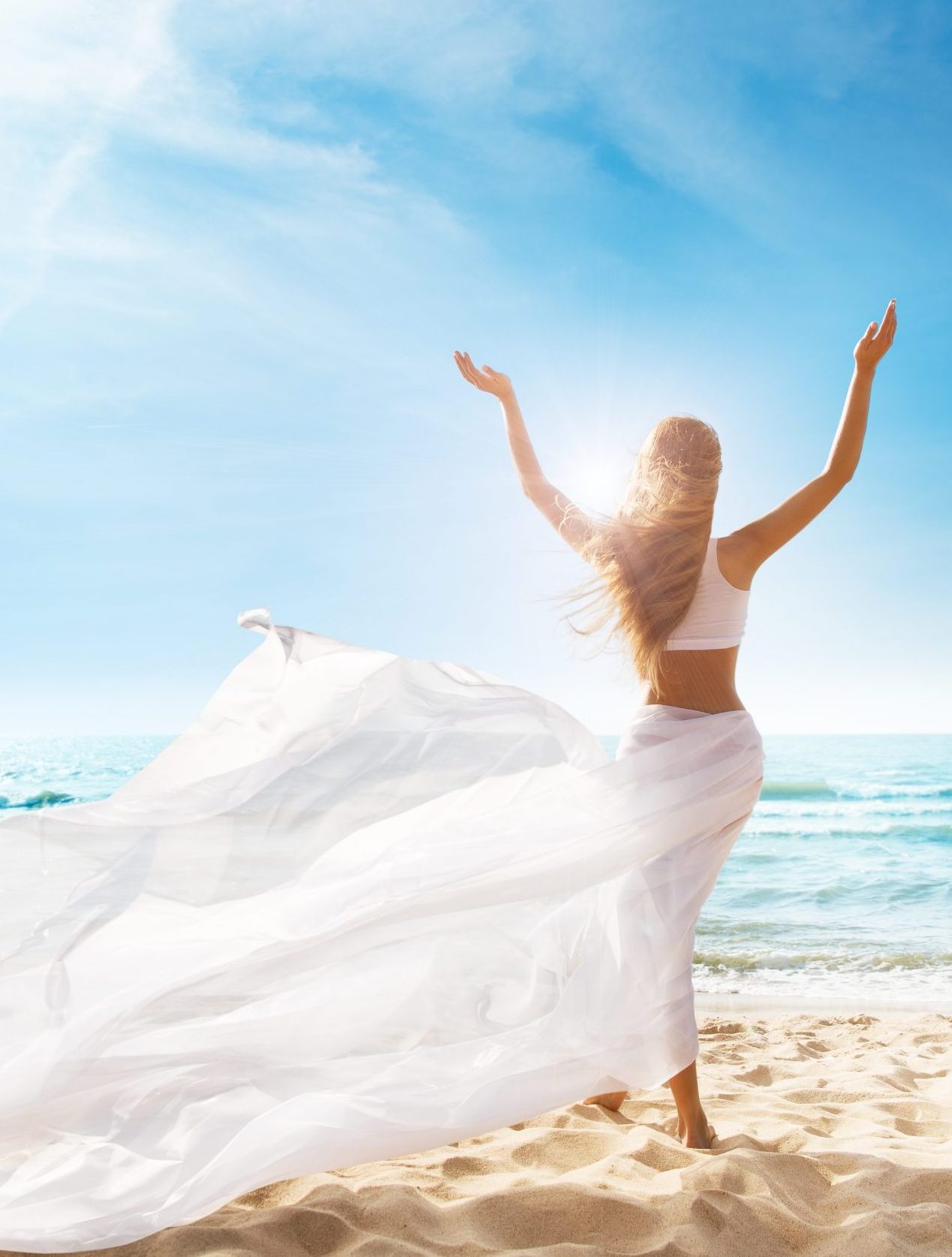 Happy Freedom Woman on Beach Enjoying Sun Arms Outstretched. Rear View of Girl Raised Hands fluttering White Dress on Wind. Summer Holiday Tropical Travel. Carefree Relax
